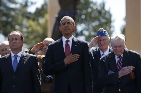 U.S. President Barack Obama (C) and French President Francois Hollande (L) stand with veterans as they participate in the 70th French-American Commemoration D-Day Ceremony at the Normandy American Cemetery and Memorial in Colleville-sur-Mer June 6, 2014. REUTERS/Kevin Lamarque