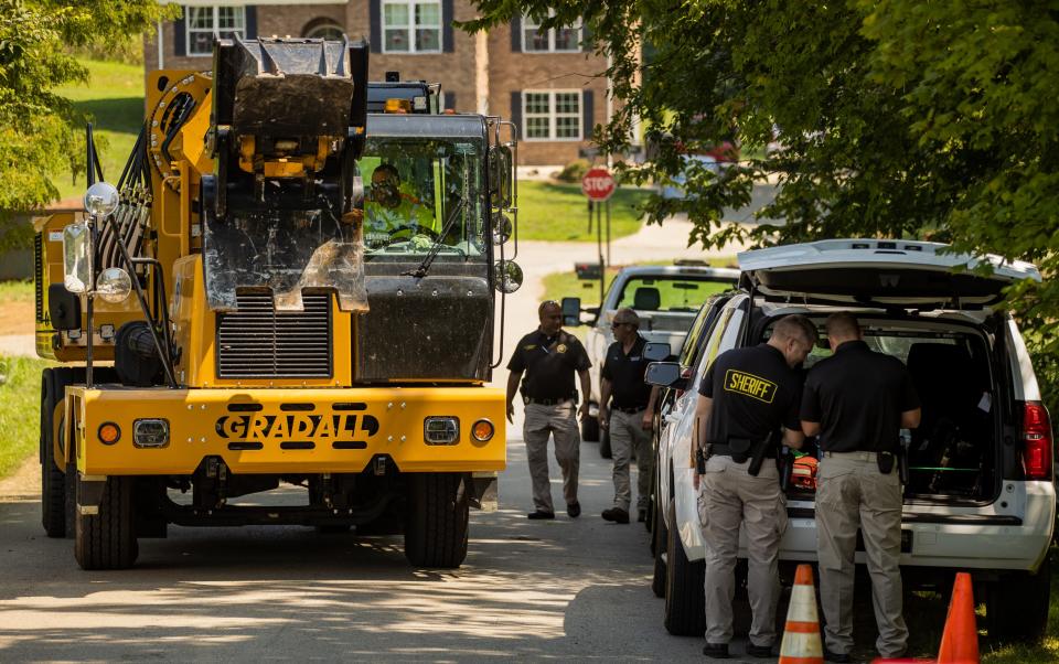 Nelson County Sheriff's Department deputies direct traffic in and out of the Bardstown subdivision where the FBI has taken the lead in Crystal Rogers missing persons case. Heavy duty equipment was brought in Thursday to help in the excavation of a driveway where the property may be linked to Rogers' former boyfriend, Brooks Houck. Aug. 26, 2021