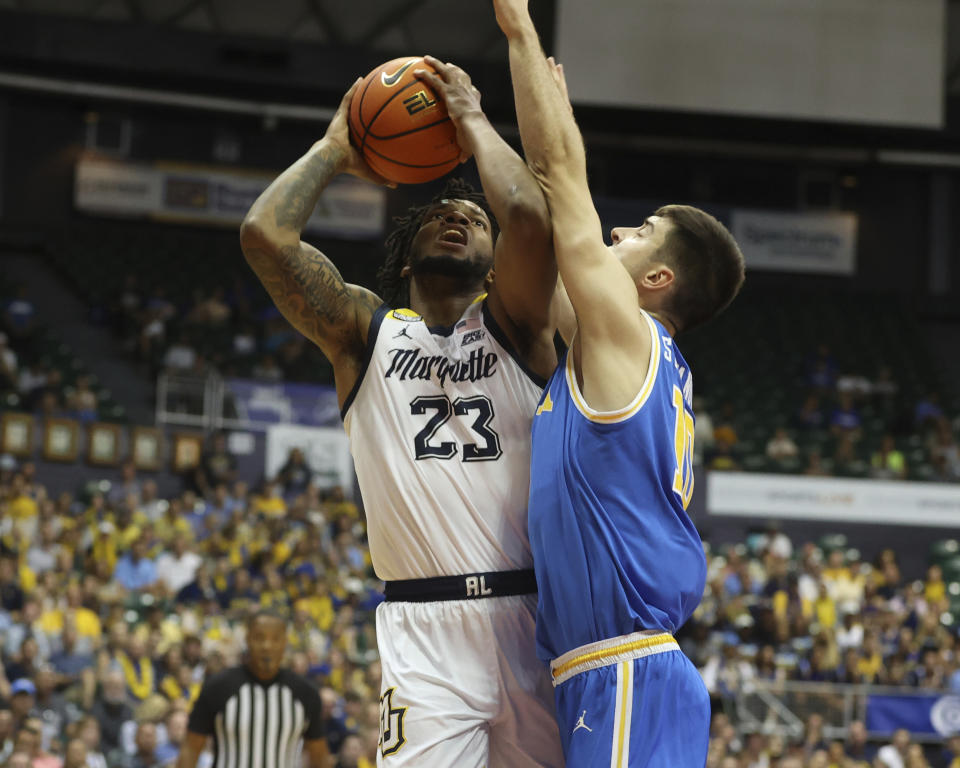 Marquette forward David Joplin (23) tries to shoot over UCLA guard Lazar Stefanovic (10) during the first half of an NCAA college basketball game, Monday, Nov. 20, 2023, in Honolulu. (AP Photo/Marco Garcia)