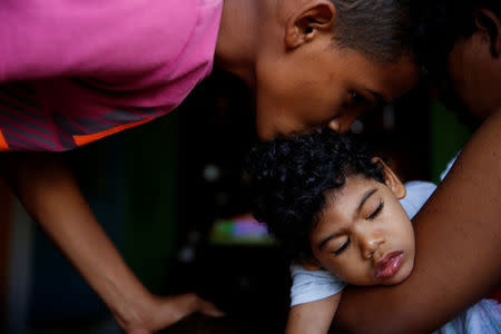 Isai Rocha (L), 14, kisses his brother Kaleth Heredia, 2, neurological patient being treated with anticonvulsants, before going out, at their house in Caracas, Venezuela January 31, 2017. REUTERS/Carlos Garcia Rawlins