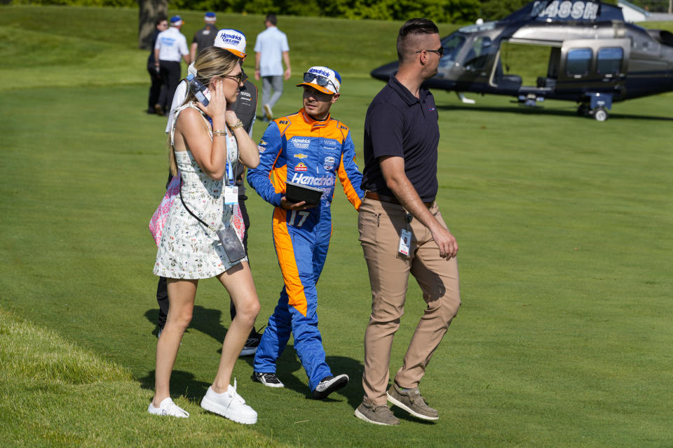 Kyle Larson, center, and his wife Katelyn Sweet board a helicopter after qualifying for the Indianapolis 500 auto race at Indianapolis Motor Speedway in Indianapolis, Sunday, May 19, 2024. (AP Photo/Michael Conroy)