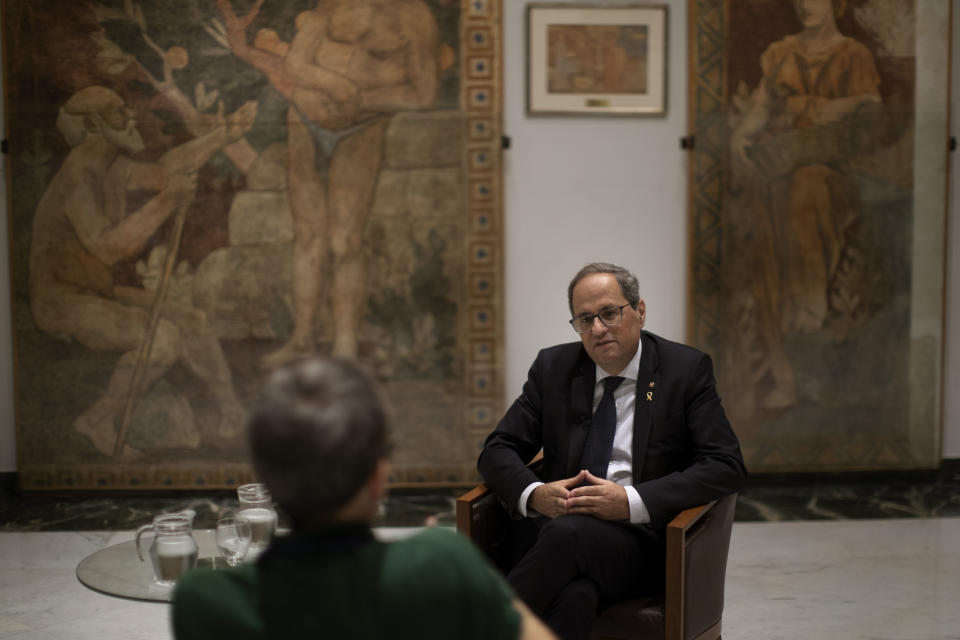 Catalan regional president Quim Torra talks with a journalist at the headquarters of the Government of Catalonia, during an interview with The Associated Press in Barcelona, Spain, Monday, Oct. 21, 2019. The leader of Catalonia says that the massive protests that have often spiralled into violent clashes with police this week won't cease until the Spanish government accepts to listen to separatists' demands. (AP Photo/Emilio Morenatti)