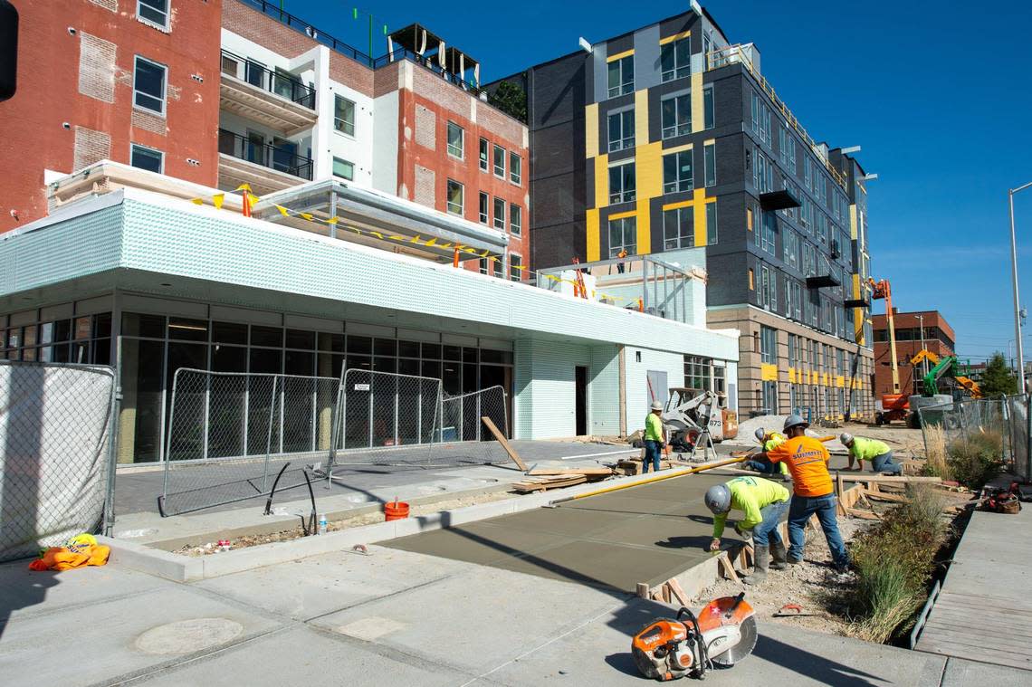 Construction workers complete the sidewalk outside the City Club Apartments Crossroads at 20th and Main streets in 2020. Rents have risen in Kansas City since since the Chiefs started their AFC championship streak in 2019.