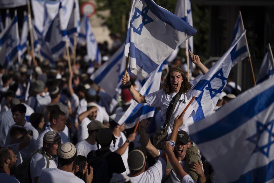 Israelis wave national flags during a march marking Jerusalem Day, an Israeli holiday celebrating the capture of east Jerusalem in the 1967 Mideast war, in front of the Damascus Gate of Jerusalem's Old City, Wednesday, June 5, 2024. Thousands of mostly ultranationalist Israelis are taking part in an annual march through a dense Palestinian neighborhood of Jerusalem’s Old City (AP Photo/Leo Correa)