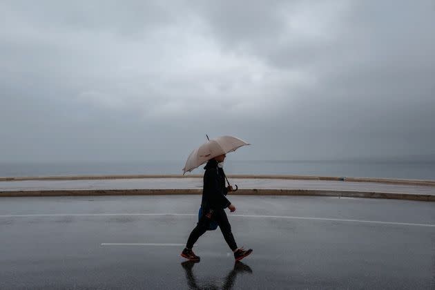 Un passant marche sous la pluie à Nice, le 19 avril 2020 (Photo: VALERY HACHE via AFP)