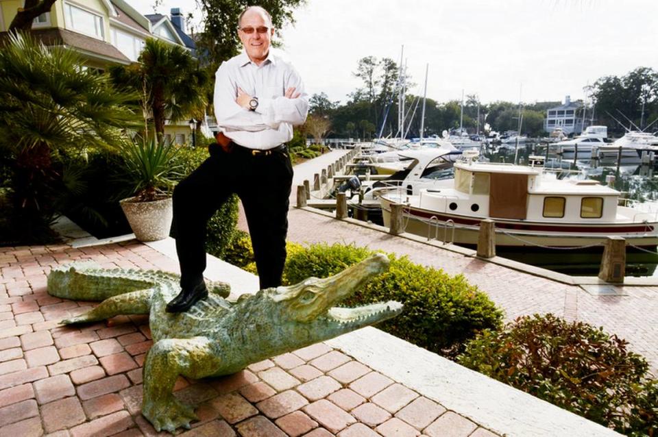 Island businessman Skip Hoagland, mastermind of the newly created Hilton Head Visitor and Convention Bureau, stands by his life-size alligator sculpture outside his Windmill Harbour home on Tuesday.