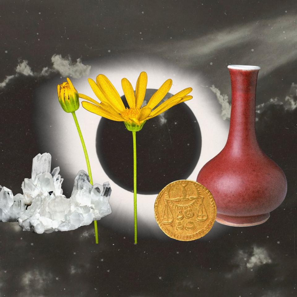 a red vase, yellow flowers, a coin, crystals, and a solar eclipse