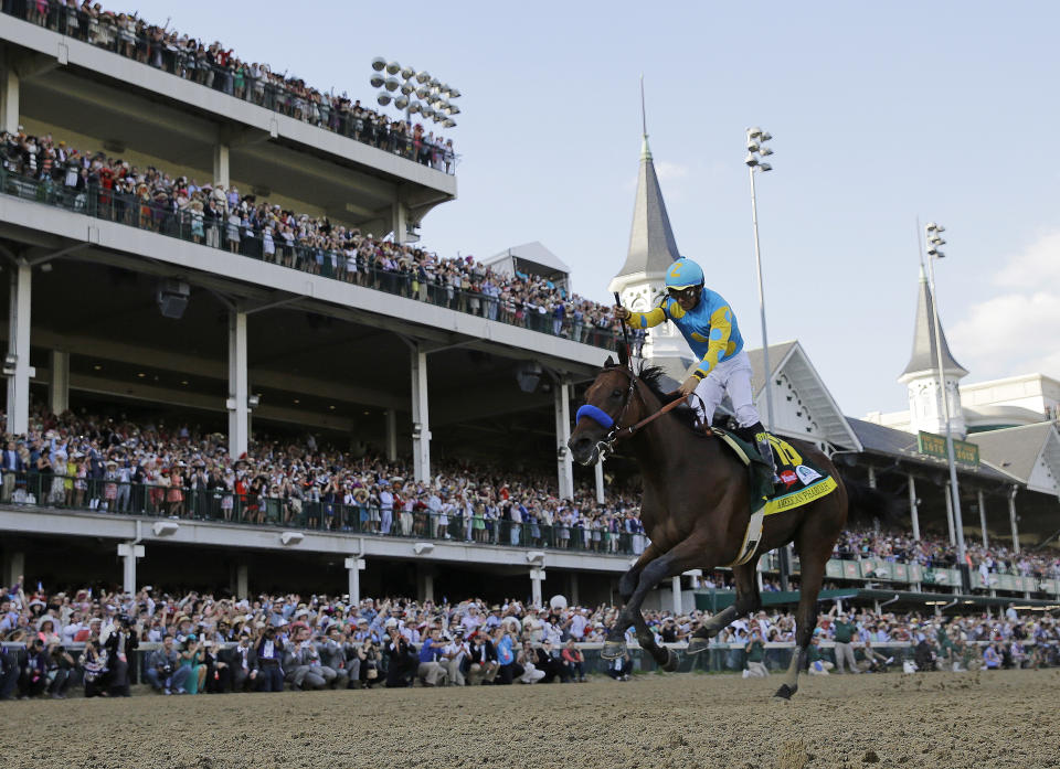 FILE - Victor Espinoza rides American Pharoah to victory in the 141st running of the Kentucky Derby horse race at Churchill Downs in Louisville, Ky., May 2, 2015.(AP Photo/David J. Phillip, File)
