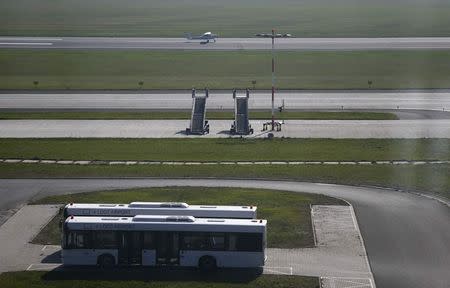 A plane is seen landing on the tarmac through the window of the control tower at the airport in Lodz October 10, 2014. REUTERS/Kacper Pempel