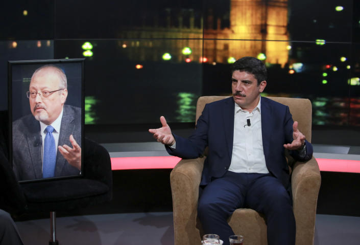 Yasin Aktay, an advisor to Turkey's President Recep Tayyip Erdogan and a good friend sits next to an empty chair with a picture of Saudi writer Jamal Khashoggi placed on it, speaks during a live television program for London-based TV station al-Hewar, in Istanbul, late Thursday, Oct. 11, 2018. Khashoggi was supposed to appear on the show. The TV presenter Azzam Tamimi, a prominent Palestinian and a good friend of Khashoggi, told The Associated Press that the program was planned to discuss his new projects, his books and other issues.(AP Photo/Mucahid Yapici)