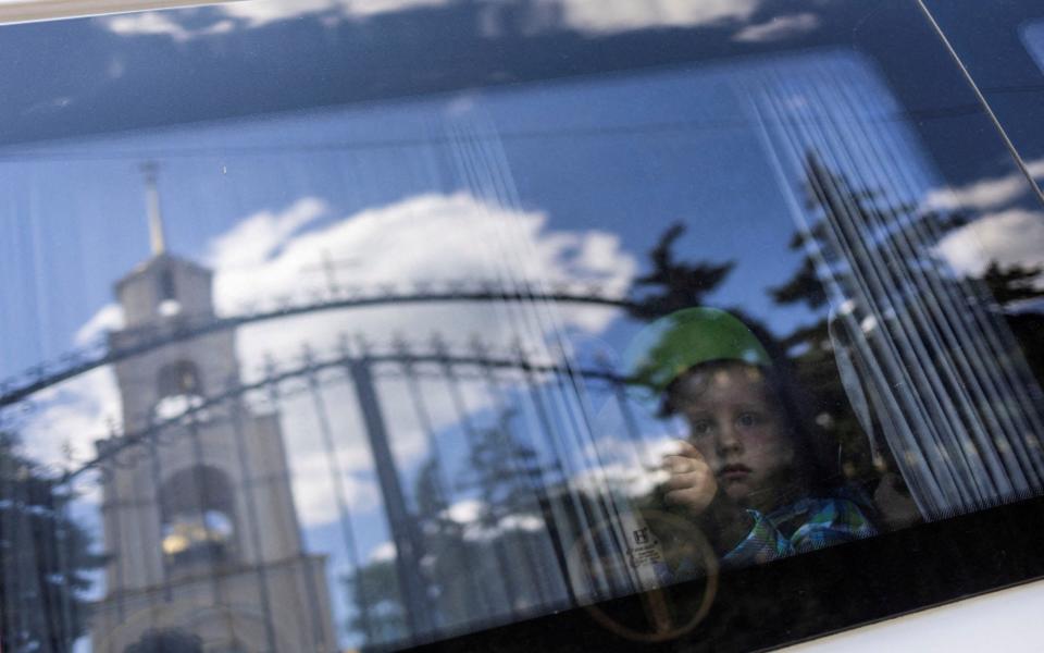 A boy looks through the window of a minibus as he and his family are being evacuated in the city of Slovyansk, Donetsk - CARLOS BARRIA /REUTERS