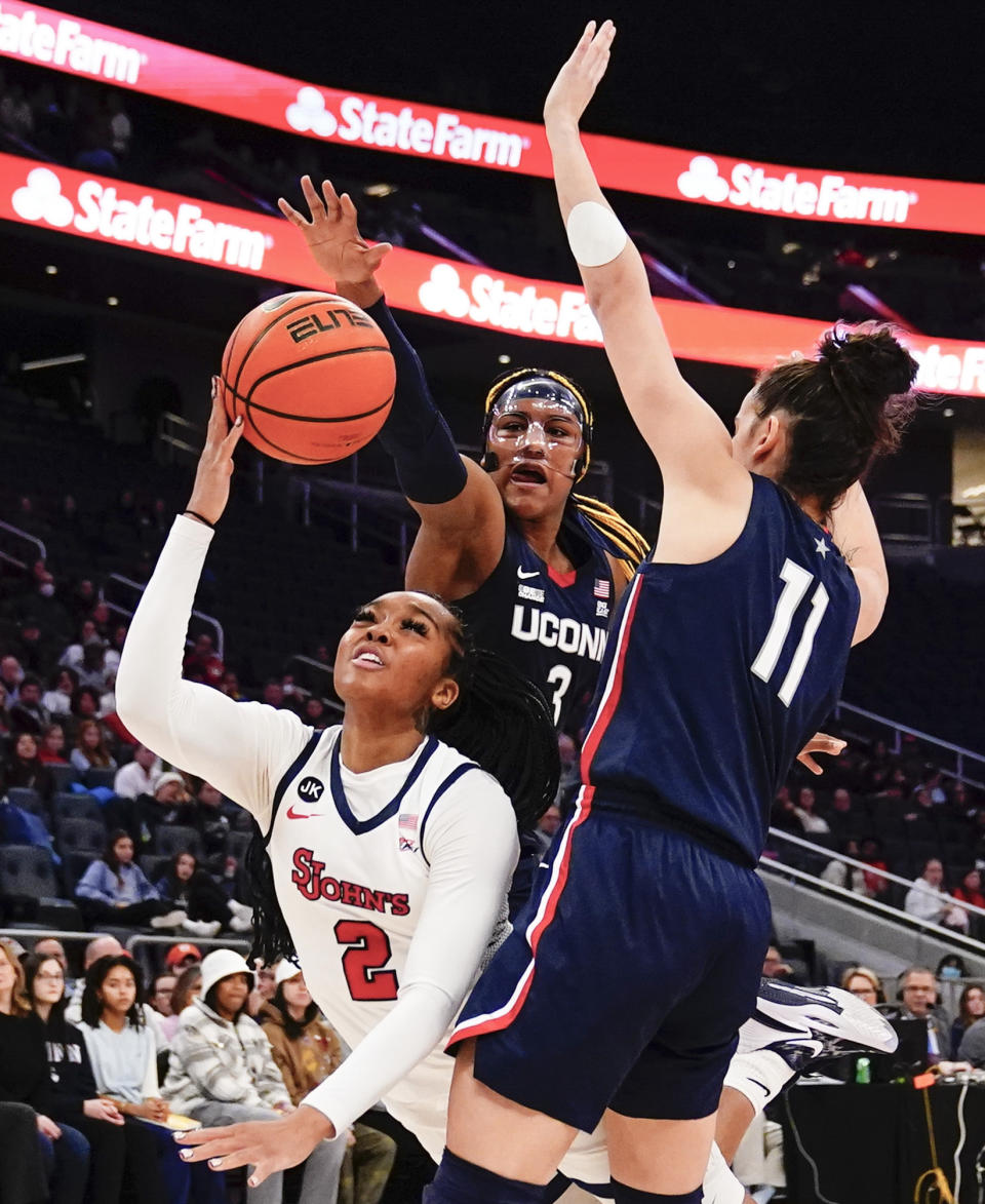 St. John's Mimi Reid (2) drives past Connecticut's Aaliyah Edwards (3) and St. John's Sitota Gines (11) during the first half of an NCAA basetball game Wednesday, Jan. 11, 2023, in New York. (AP Photo/Frank Franklin II)