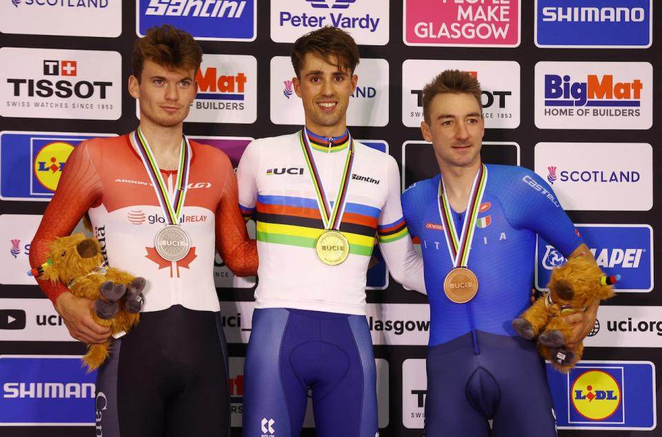 Canada's Dylan Bibic, left, celebrates his silver medal in the men's elite elimination race on Monday at the 2023 UCI Cycling World Championships in Scotland, alongside gold medallist Ethan Vernon of Great Britain and bronze medallist Elia Viviani of Italy. (Matthew Childs/Reuters - image credit)