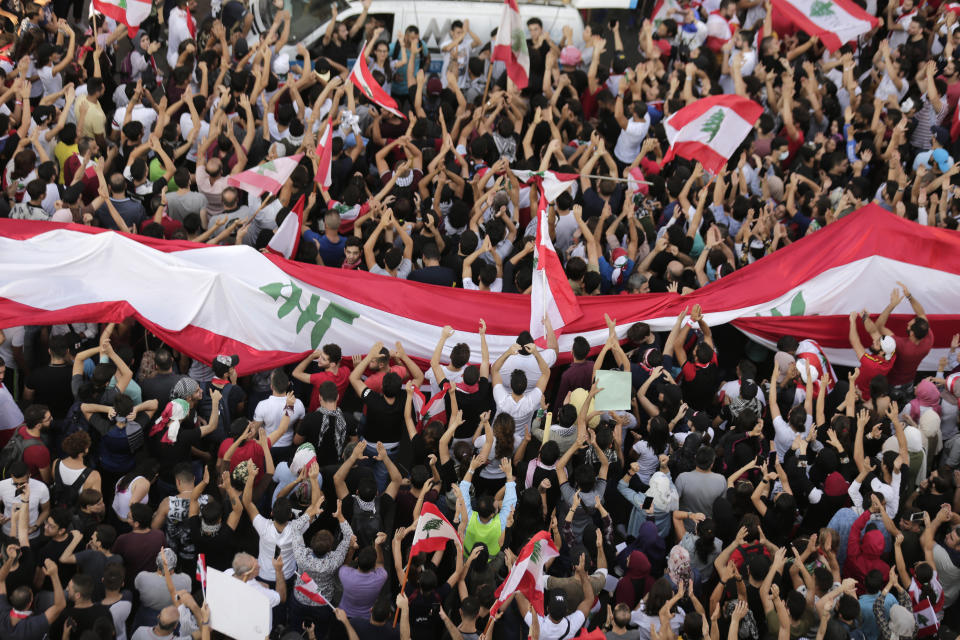 Anti-government protesters shout slogans in Beirut, Lebanon, Sunday, Oct. 20, 2019. Tens of thousands of Lebanese protesters of all ages gathered Sunday in major cities and towns nationwide, with each hour bringing hundreds more people to the streets for the largest anti-government protests yet in four days of demonstrations. (AP Photo/Hassan Ammar)