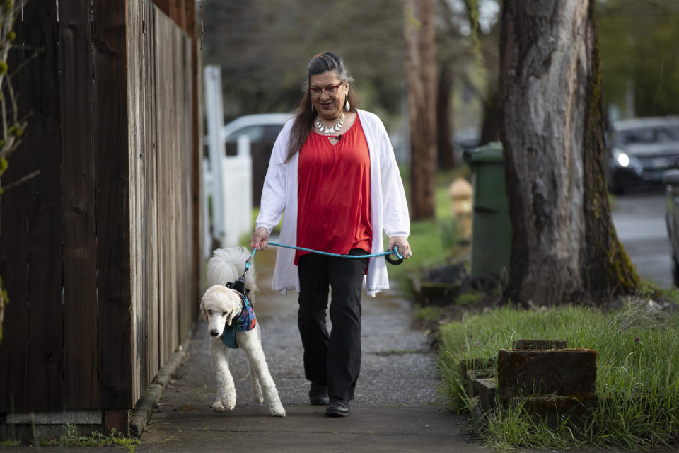 Christina Wood walks her poodle, Max, in Salem, Ore., Friday, April 21, 2023. For most of her life in New Mexico, Wood felt like she had to hide her identity as a transgender woman. So six years ago she moved to Oregon, where she could access the gender-affirming health care she needed to live as her authentic self. (AP Photo/Amanda Loman)