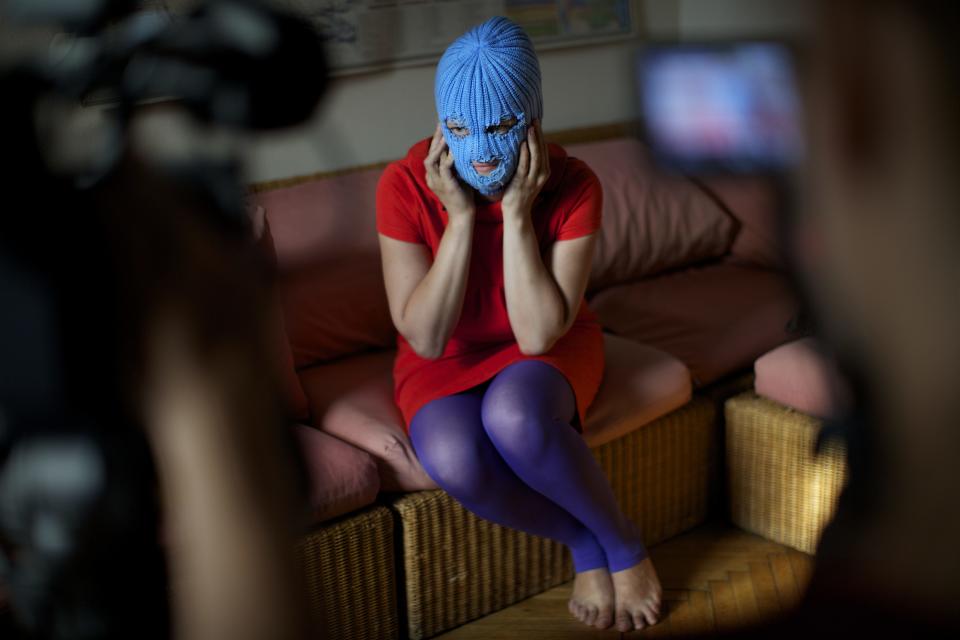 A member of Russian punk band Pussy Riot, who gave only her stage name of Grelka, wears a blue balaclava as speaks to the media in Moscow, Tuesday, July 16, 2013. Russian provocateurs Pussy Riot are back in action, releasing their first music video since three members went to prison last year for a prank denouncing Vladimir Putin. The video shows band members in trademark bright-colored balaclavas and short skirts, cavorting and shrieking atop an oil rig. Backed by hectic guitar and a drum fusillade, they pour oil on a large photo of state oil giant Rosneft’s chairman and liken Putin to an Iranian ayatollah. Pussy Riot member Grelka said after the video’s Tuesday release that “the main message is that Putin has spread the country’s wealth among his friends.” (AP Photo/Alexander Zemlianichenko)