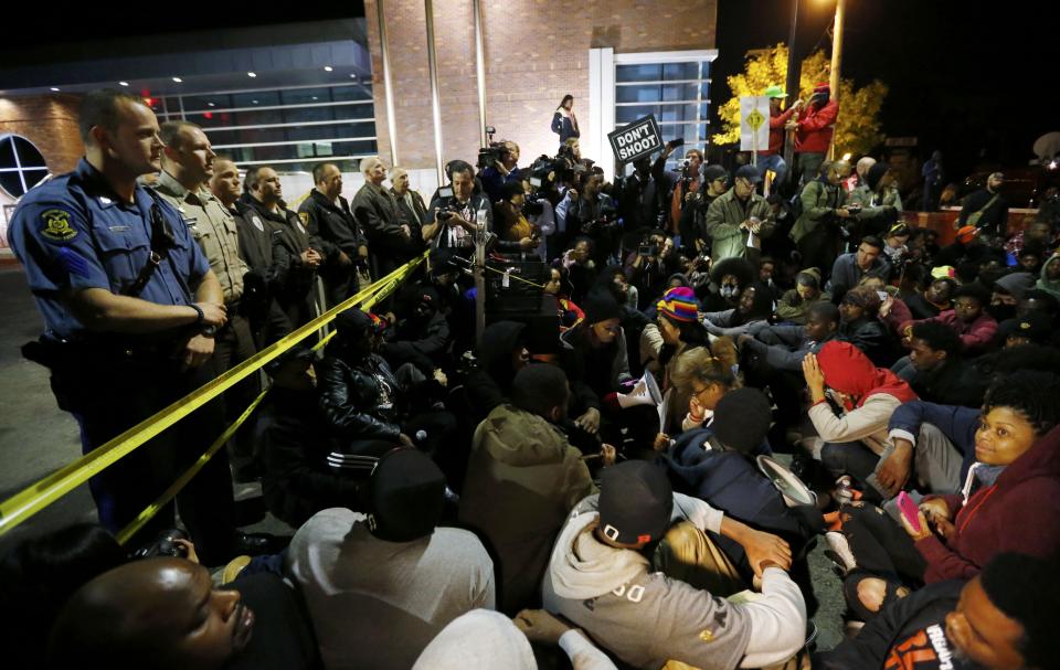 Protesters participate in a sit-in during a rally for Michael Brown outside the police department in Ferguson, Missouri, October 11, 2014. (REUTERS/Jim Young)