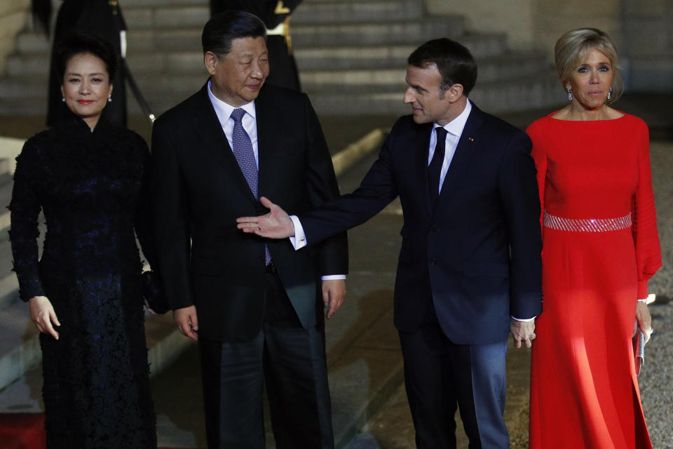 French President Emmanuel Macron, 2nd right, his wife Brigitte Macron, right, Chinese President President Xi Jinping, second left, and his wife Peng Liyuan, left, pose prior to a state dinner at the Elysee Palace in Paris, France, Monday, March 25, 2019. Chinese President Xi Jinping is on a 3-day state visit in France where he is expected to sign a series of bilateral and economic deals on energy, the food industry, transport and other sectors. (AP Photo/Francois Mori)