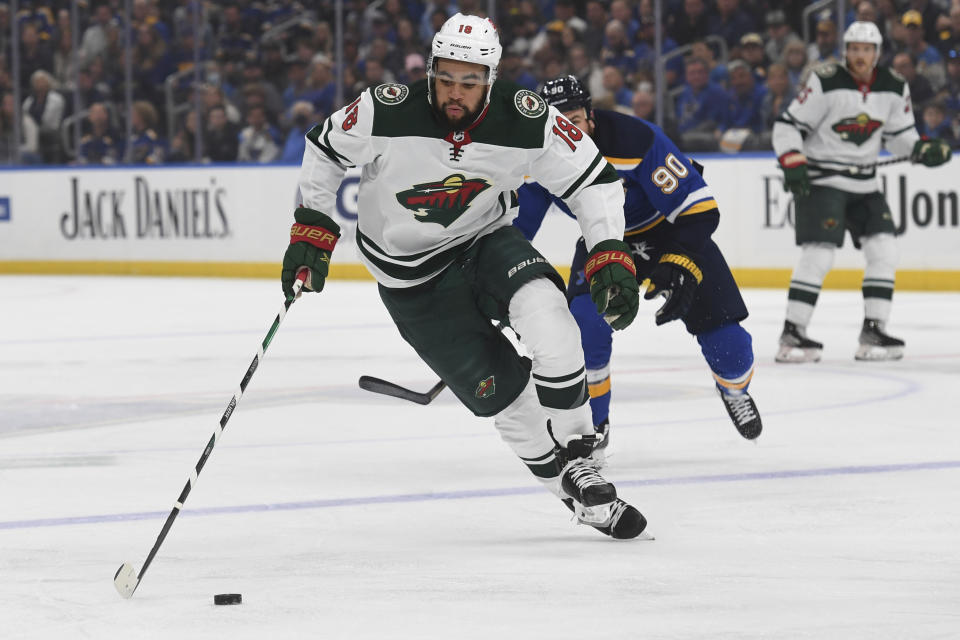 Minnesota Wild's Jordan Greenway (18) advances the puck during the first period in Game 4 of an NHL hockey Stanley Cup first-round playoff series against the St. Louis Blues, Sunday, May 8, 2022, in St. Louis. (AP Photo/Michael Thomas)