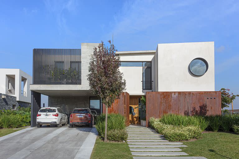 Foto de la entrada de una casa con revestimiento de acero y patio de ingreso.