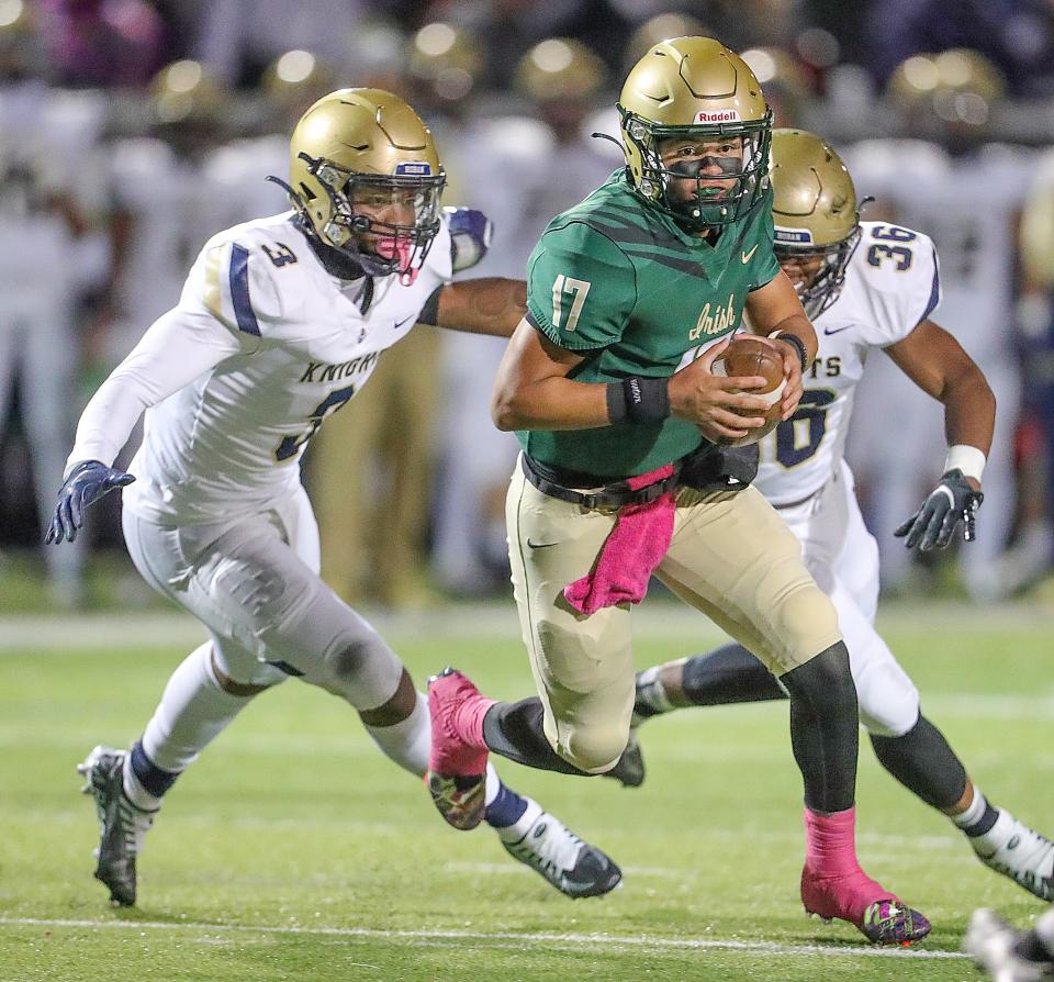 St. Vincent-St. Mary quarterback Gabe Mansel is chased out of the pocket by Hoban's Rickey Williams, left, and Deon Rodgers on Oct. 7, 2022.