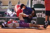 A physiotherapist takes care of Stefanos Tsitsipas of Greece as he plays Serbia's Novak Djokovic during their final match of the French Open tennis tournament at the Roland Garros stadium Sunday, June 13, 2021 in Paris. (AP Photo/Michel Euler)