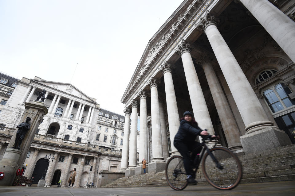 A woman cycles past the Bank of England and the Royal Exchange in the City of London.