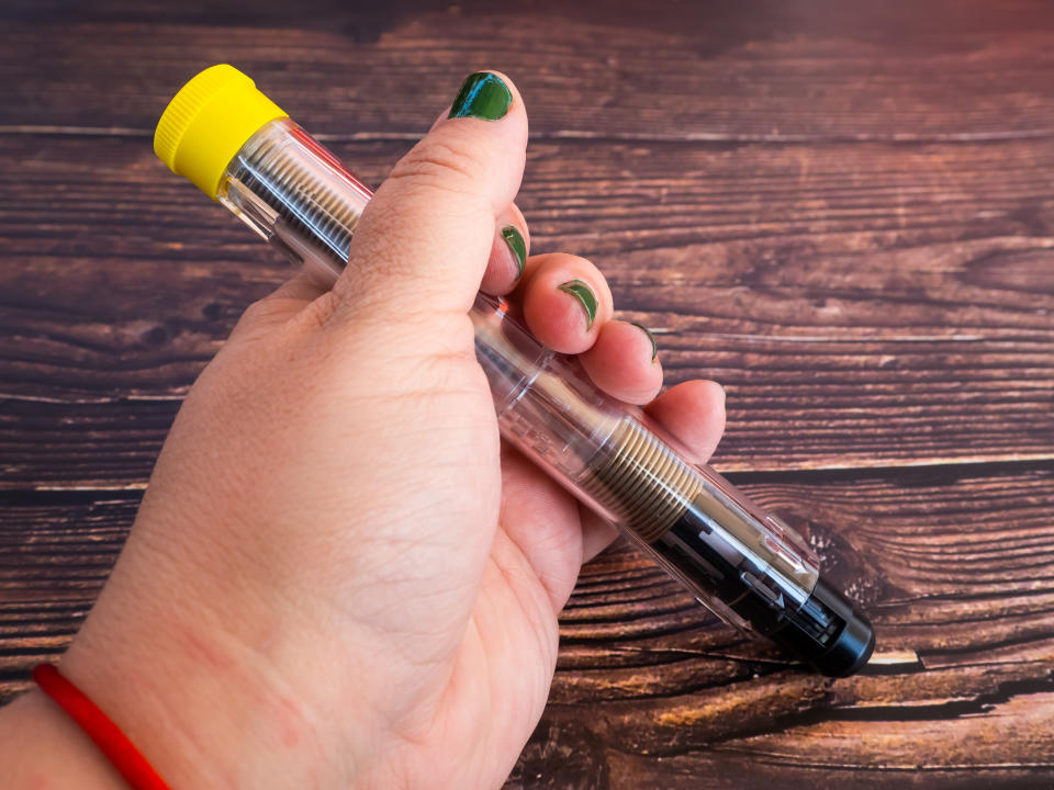 One person with an adrenalin injection pen in her hand on a wooden table. Anaphylaxis needs to be treated promptly with epinephrine. (Getty)