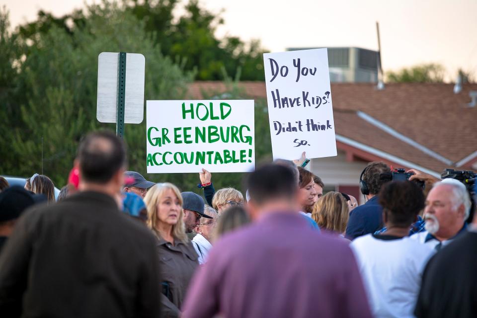 A lively crowd of parents and students stands with signs calling for the resignation of Scottsdale Unified School District board member Jann-Michael Greenburg during a rally outside Coronado High School in Scottsdale on Nov. 30, 2021.