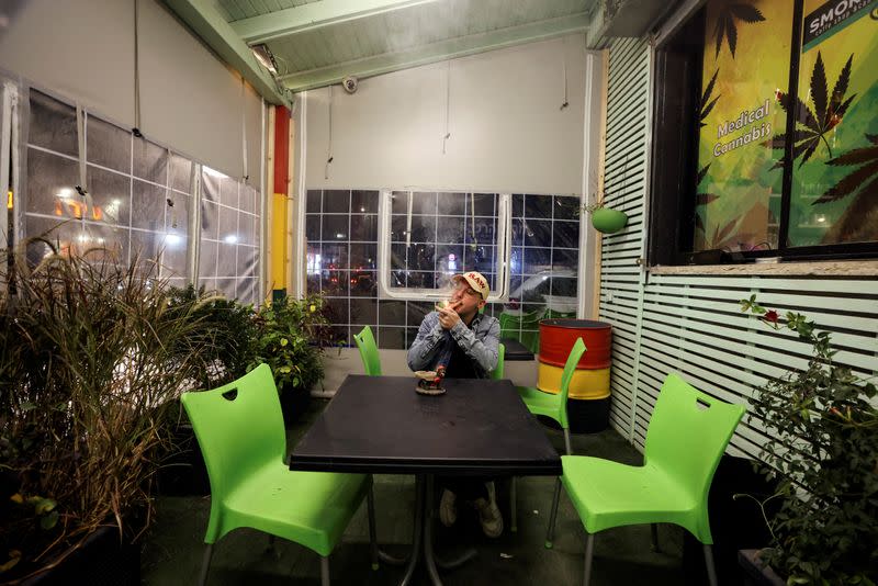 FILE PHOTO: A worker smokes a joint at a medical cannabis cafe in Tira, an Arab village in central Israel