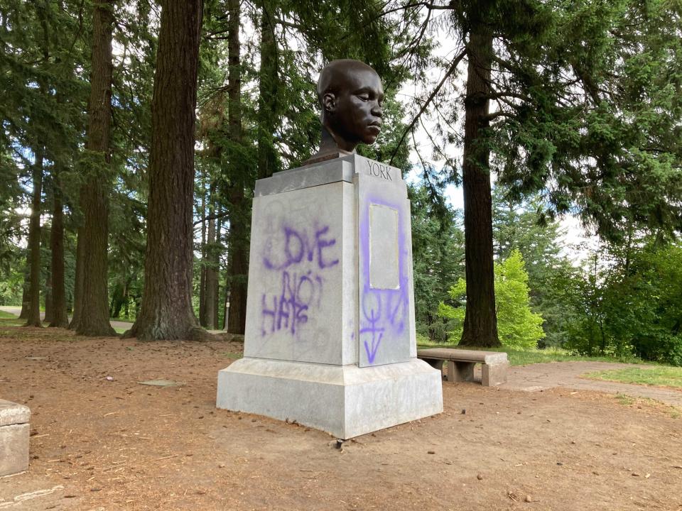 This Thursday, June 10, 2021 photo shows a statue commemorating York, an enslaved Black member of the Lewis and Clark Expedition, after being defaced in Portland, Ore. (Catalina Gaitán/The Oregonian via AP)