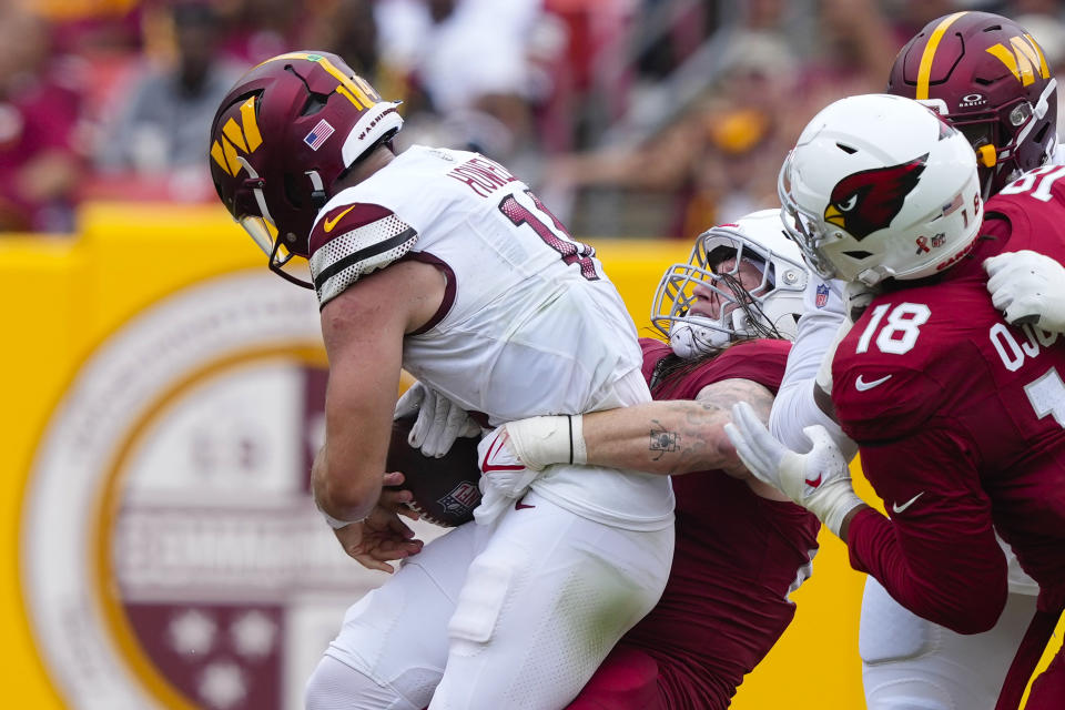 Washington Commanders quarterback Sam Howell (14) is sacked by Arizona Cardinals linebacker Dennis Gardeck (45) during the first half of an NFL football game, Sunday, Sept. 10, 2023, in Landover, Md. (AP Photo/Susan Walsh)