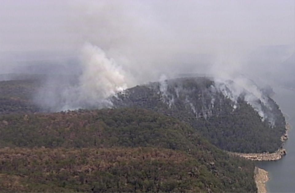 In this image made from video, smoke rises from wildfires Friday, Dec. 27, 2019, in the Blue Mountains, New South Whales, Australia. Firefighters battling wildfires in Australia’s most populous state are attempting to make headway amid favorable conditions, before an "extreme heatwave" hits embattled areas on the weekend. (Australian Broadcasting Corporation via AP)