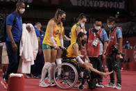 Brazil's Rosamaria Montibeller, #7, pushes in a wheelchair her teammate Macris Fernanda Silva Carneiro who was injured during a women's volleyball preliminary round pool A match against Japan, at the 2020 Summer Olympics, Thursday, July 29, 2021, in Tokyo, Japan. (AP Photo/Manu Fernandez)