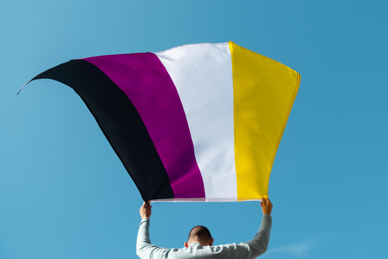 A person waves a Nonbinary Pride flag. (Getty Images)