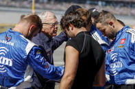 Team owner Joe Gibbs, center, leads the crew of driver Christopher Bell in prayer before the NASCAR Cup Series auto race Sunday, Oct. 2, 2022, in Talladega, Ala. (AP Photo/Butch Dill)