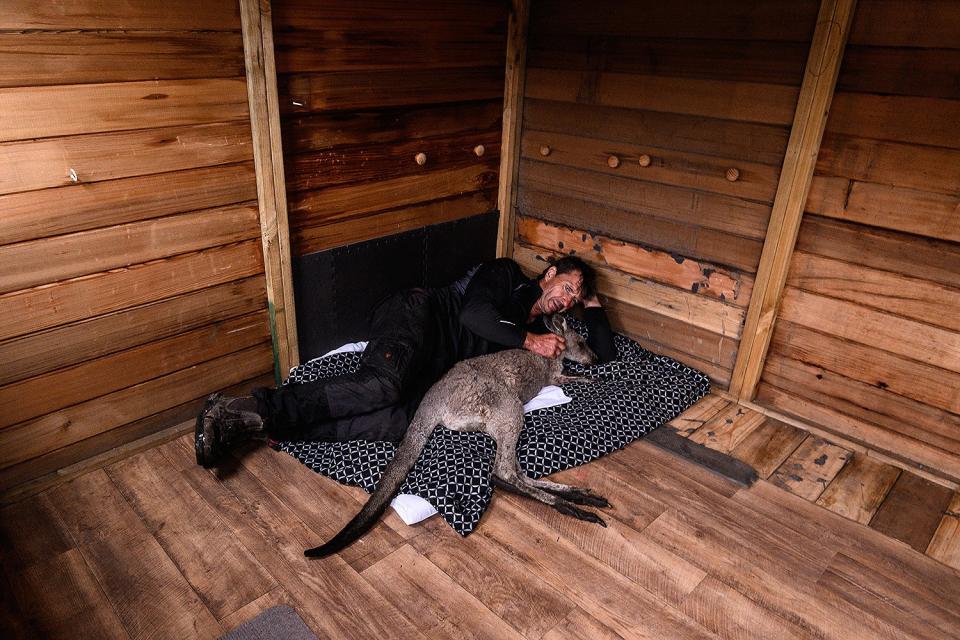 Gary Henderson lies next to a young, injured kangaroo on Jan. 16. Henderson and his partner, Sara Tilling, are nursing the animal back to health in Cobargo, Australia. The pair used to run the Cobargo Wildlife Sanctuary from their home, which was lost in a bushfire along with all their animals, and have only been able to rescue one kangaroo.