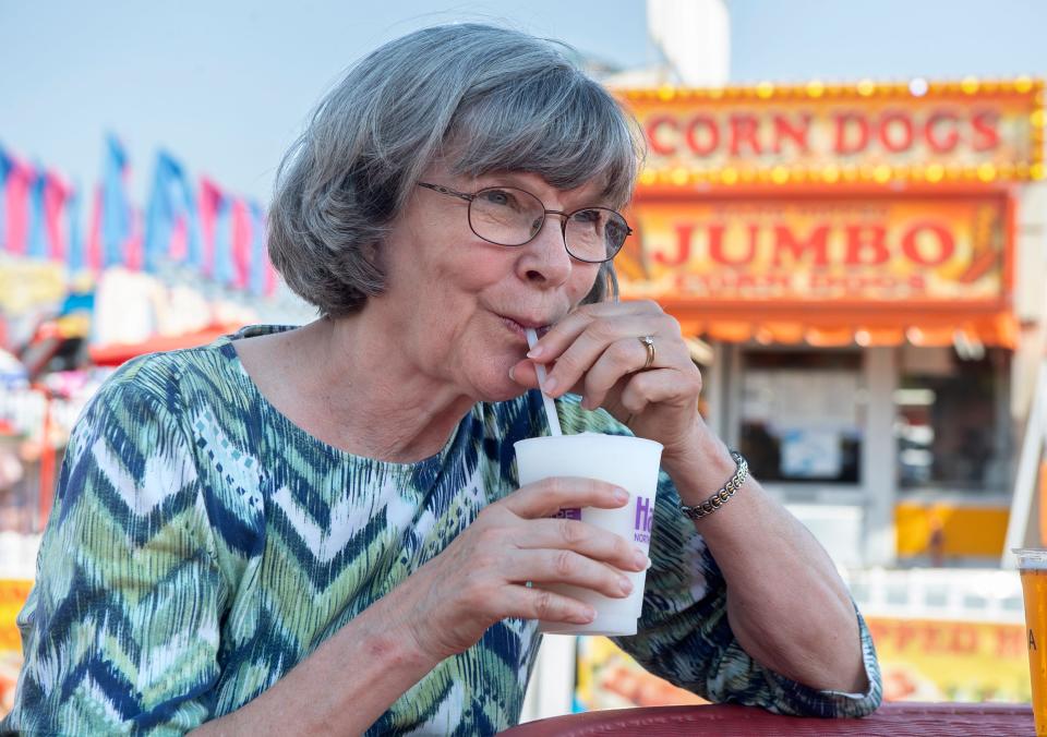 (9/16/22)Hennie Van Konynenburg of Modesto takes a sip of a wine slushie at the annual Lodi Grape Festival at the Grape Festival Grounds in Lodi on Friday, September 16, 2022.  Van Konynenburg is in open shade. 