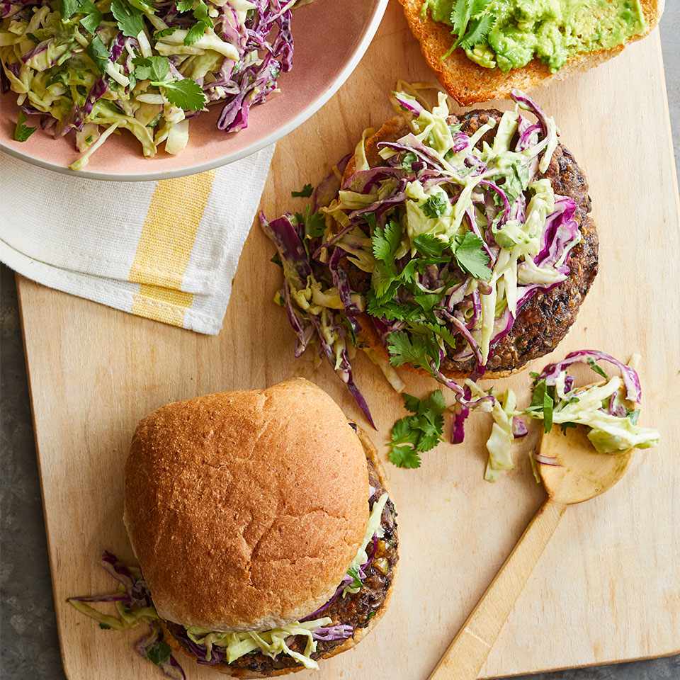 <p>Lighten up your burger! Bean patties have less saturated fat and more fiber than beef patties. They're also cheaper and easier to cook indoors--and we promise they're just as satisfying, especially with the mouthwatering creamy slaw on top.</p> <p> <a href="https://www.eatingwell.com/recipe/269118/cilantro-bean-burgers-with-creamy-avocado-lime-slaw/" rel="nofollow noopener" target="_blank" data-ylk="slk:View Recipe;elm:context_link;itc:0;sec:content-canvas" class="link ">View Recipe</a></p>