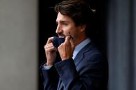 FILE PHOTO: Canada's Prime Minister Justin Trudeau removes his face mask after arriving to a news conference following a cabinet retreat in Ottawa