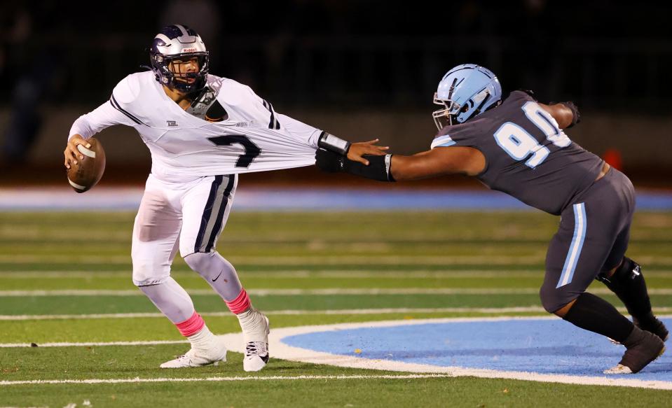 Hunter’s quarterback Uluaki Taukiuvea tries to get away from Granger’s Mason Kasataki as they play at Granger in West Valley City on Wednesday, Oct. 11, 2023. | Scott G Winterton, Deseret News