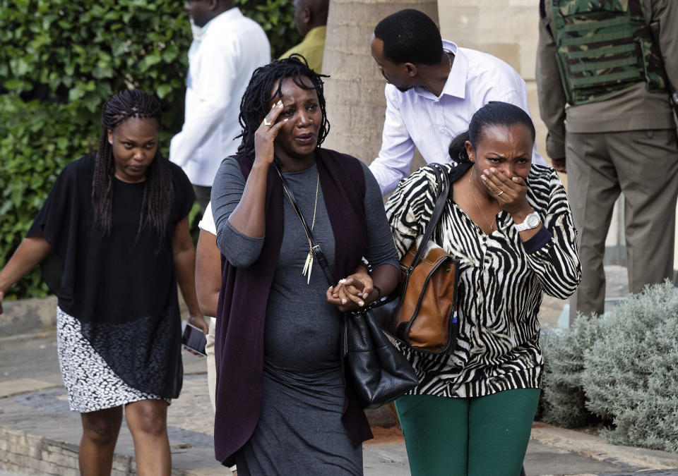 Civilians flee the scene at a hotel complex in Nairobi, Kenya Tuesday, Jan. 15, 2019. Terrorists attacked an upscale hotel complex in Kenya's capital Tuesday, sending people fleeing in panic as explosions and heavy gunfire reverberated through the neighborhood. (AP Photo/Ben Curtis)