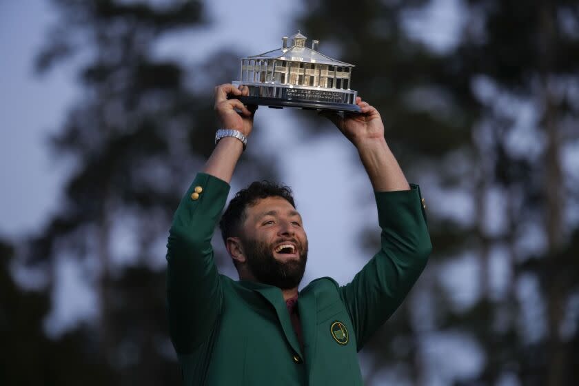 Jon Rahm, of Spain, celebrates holding the Masters trophy winning the Masters.