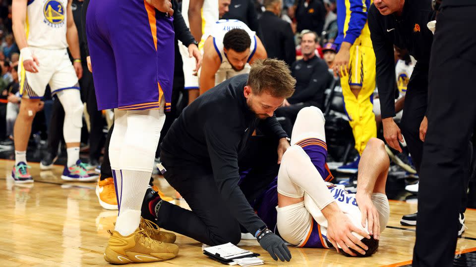 Jusuf Nurkić receives treatment after being hit in the face by Green. - Mark J. Rebilas/USA TODAY Sports/Reuters