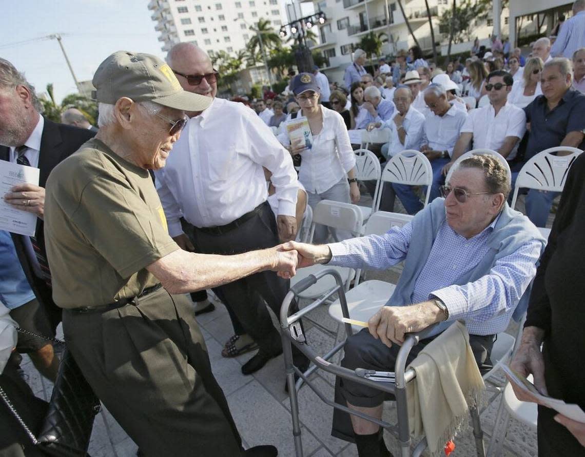 Above: In 2016, Holocaust survivor Tibor Hollo, 90, shakes hands with Harry Smith, a founder of the Holocaust Memorial, during Holocaust Remembrance Day in Miami Beach. ANDREW ULOZA/FOR THE MIAMI HERALD
