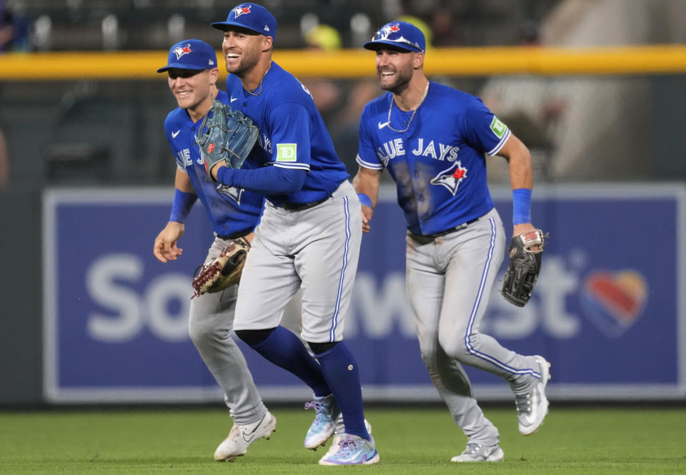 Toronto Blue Jays left fielder Daulton Varsho, right fielder George Springer and center fielder Kevin Kiermaier, from left, celebrate after the team's baseball game against the Colorado Rockies on Friday, Sept. 1, 2023, in Denver. (AP Photo/David Zalubowski)