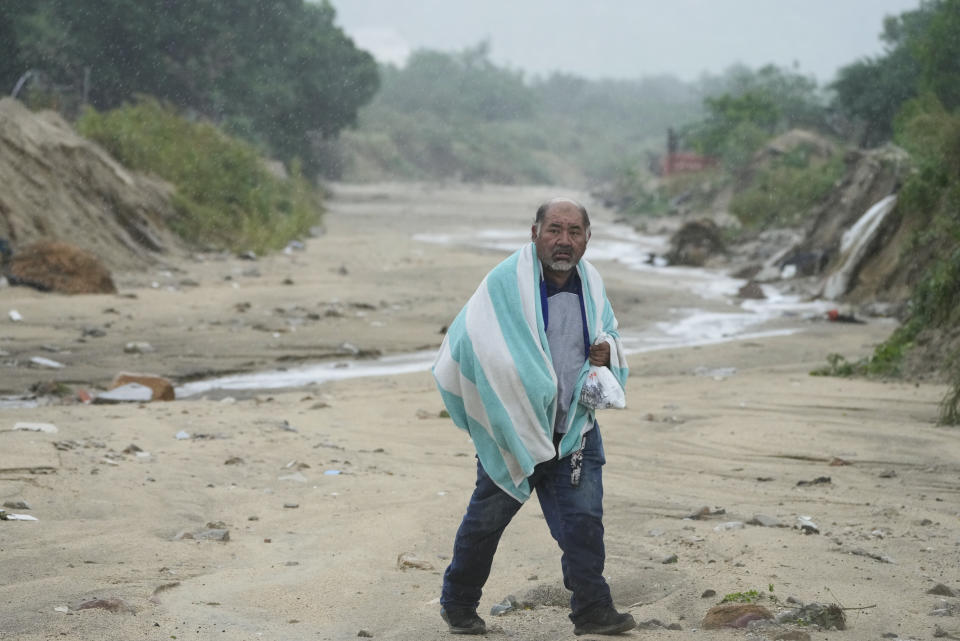 A man walks on the mud caused by hurricane Norma in San Jose del Cabo, Mexico, Saturday, Oct. 21, 2023. Norma had weakened and was downgraded to Category 1 on the hurricane wind scale. It was located 25 miles west of Cabo San Lucas storm with winds of 85 mph (140 kmh) and expected to make landfall on Saturday, according to the U.S. (AP Photo/Fernando Llano)