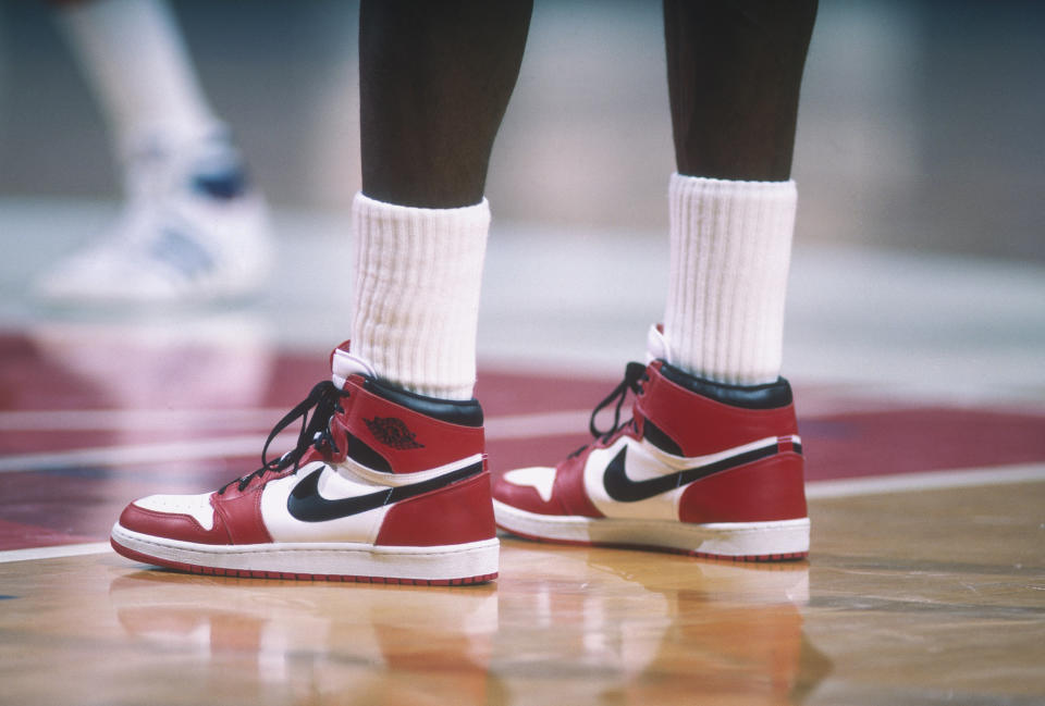 air jordan 1 history, WASHINGTON - 1985:  Detail of the "Air Jordan" Nike shoes worn by Chicago Bulls' center Michael Jordan #23 during a game against the Washington Bullets at Capital Centre circa 1985 in Washington, D.C.. NOTE TO USER: User expressly acknowledges and agrees that, by downloading and or using this photograph, User is consenting to the terms and conditions of the Getty Images License Agreement. (Photo by Focus on Sport via Getty Images)