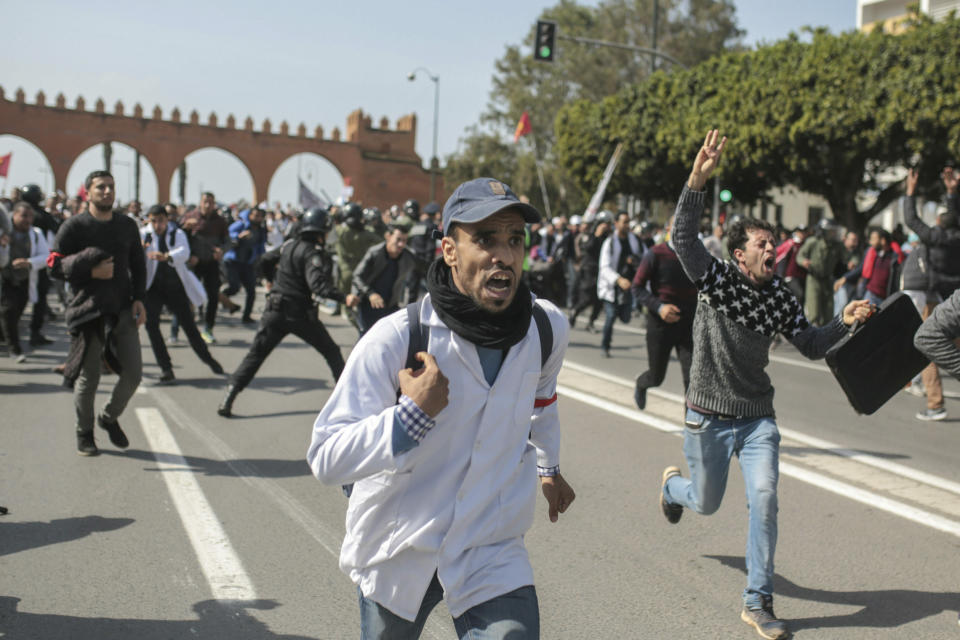 Protesting teachers run from security forces attempting to disperse a demonstration in Rabat, Morocco, Wednesday, Feb. 20, 2019. Moroccan police fired water cannons at protesting teachers who were marching toward a royal palace and beat people with truncheons amid demonstrations around the capital Wednesday. (AP Photo/Mosa'ab Elshamy)