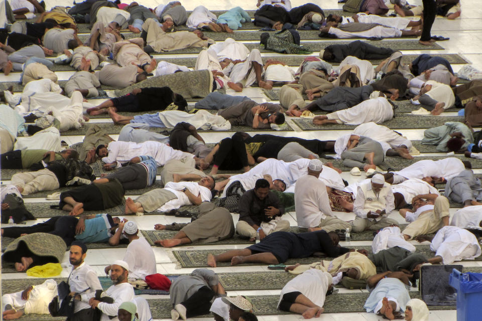 Muslim pilgrims take a nap after dawn prayers outside the Grand Mosque, during the annual hajj pilgrimage in Mecca, Saudi Arabia, Monday, June 26, 2023, before heading to Mina in preparation for the Hajj, the fifth pillar of Islam and one of the largest religious gatherings in the world. (AP Photo/Amr Nabil)